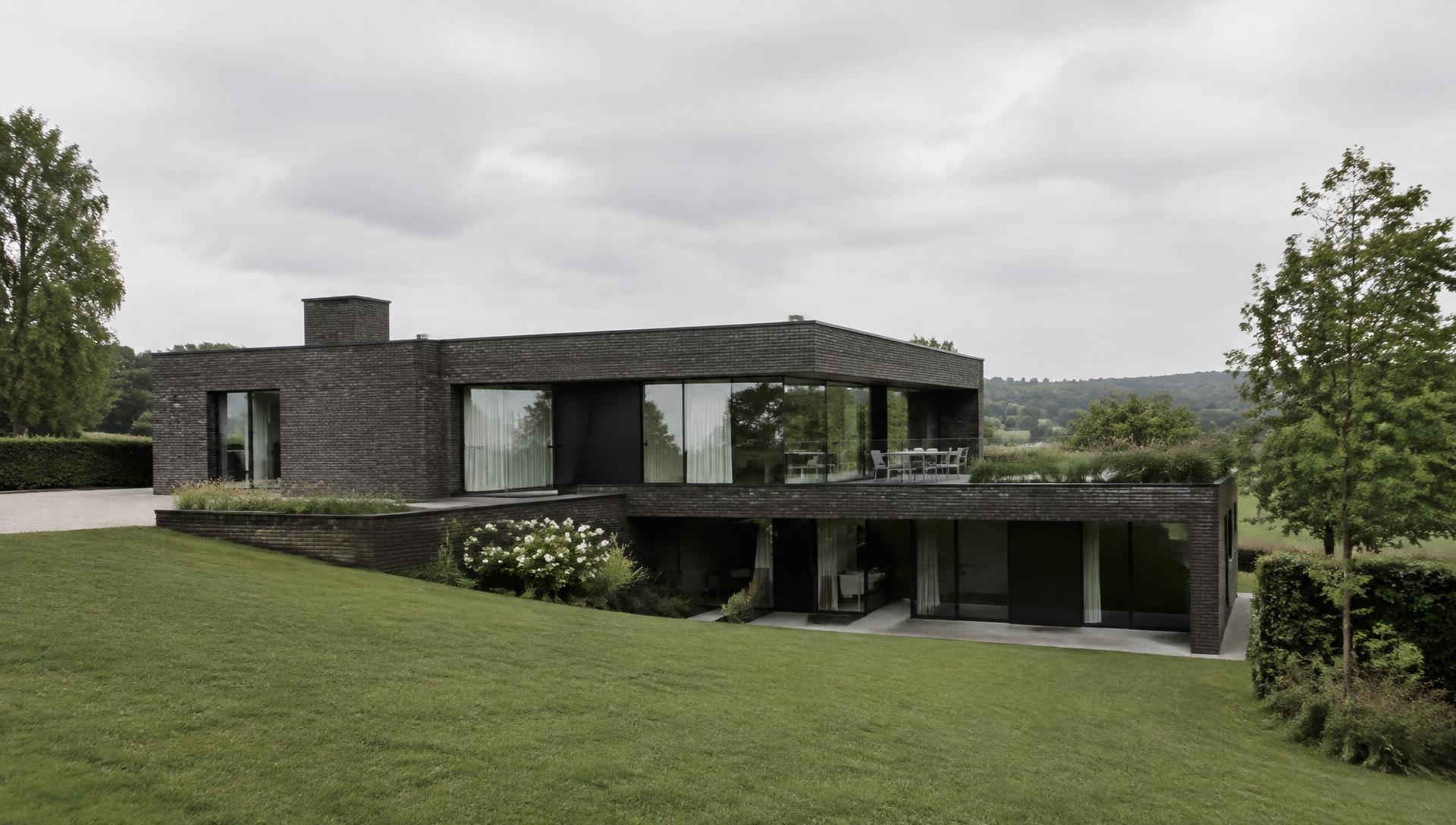 Fictief minimalistisch woonhuis in donkere baksteen in heuvellandschap
